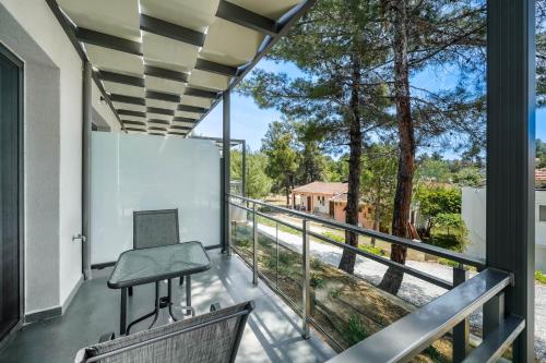 a room with a balcony with a table and chairs at Pine Suites in Potos