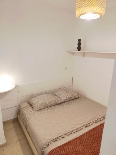 a bed in a room with a white wall at Bistra in Ajdovščina