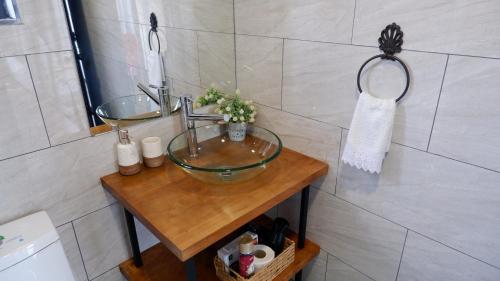 a bathroom with a glass sink and a shower at Cabañas Julián Elías Roja in Puerto Natales