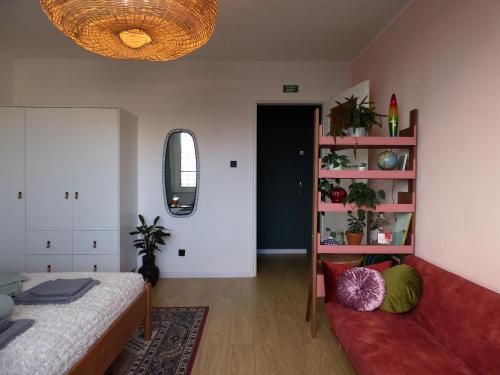 a bedroom with a bed and a book shelf at Kwiat Paproci Design Apartment Gdynia in Gdynia