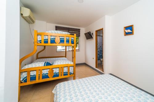 ein Schlafzimmer mit zwei Etagenbetten in einem Zimmer in der Unterkunft Pangora, habitación privada de Flor de Lis Beach House in Playas