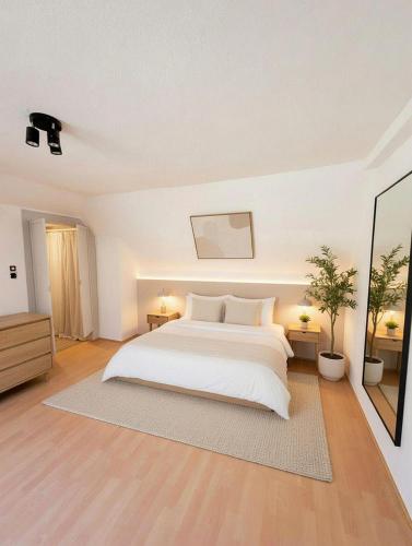 a white bedroom with a bed and a mirror at Wohnhaus mit besonderer Ausstrahlung in Bad Frankenhausen