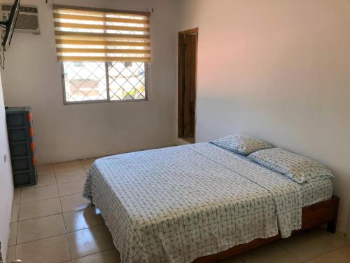 a bedroom with a bed and a window at Estela, habitación privada de Flor de Lis Beach House in Playas
