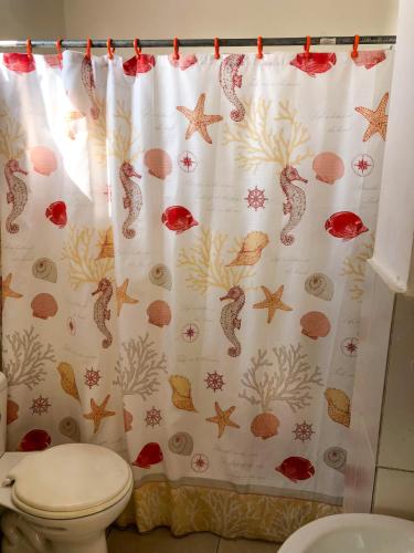 a bathroom with a shower curtain and a toilet at Estela, habitación privada de Flor de Lis Beach House in Playas