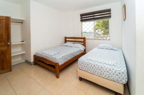 En eller flere senge i et værelse på Liza, habitación privada de Flor de Lis Beach House