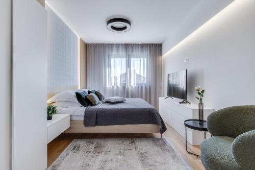 a bedroom with a bed and a tv and a couch at Shell Sky Luxury Penthouse with Private Pool in Zadar