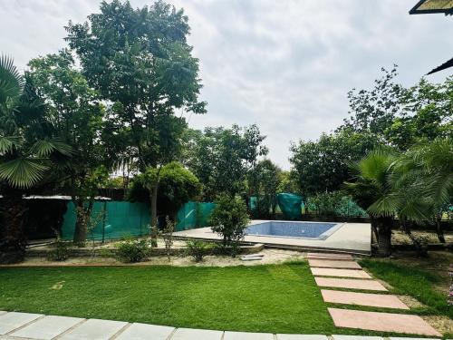 a swimming pool in a yard with trees at Rk farms in Noida