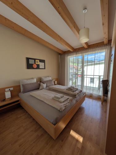 a bedroom with a large bed and a large window at Kronsun Percha in Perca