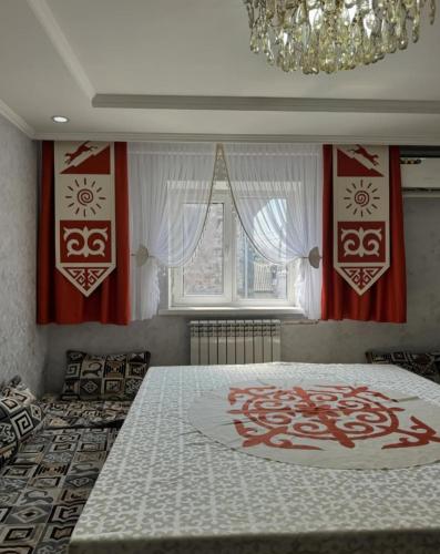 a bedroom with a large bed with a chandelier at Guest House Eltin in Bokonbayevo