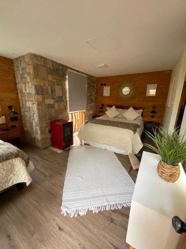 a bedroom with two beds and a stone wall at Hotel Boutique Terra Diaguita & Spa in La Serena