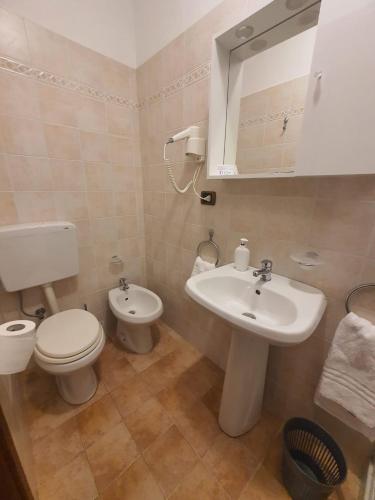 a bathroom with a white toilet and a sink at Hotel Isolabella in Bussoleno