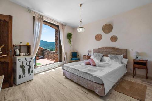 a bedroom with a bed and a large window at Chambres D'hôtes - Le Mas Du Rocher in Hyères