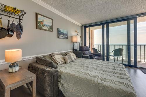 a bedroom with a bed and a couch and a balcony at Pool Access: 8th-Floor Condo on North Myrtle Beach in Myrtle Beach