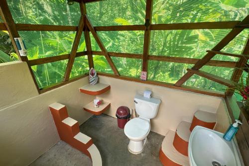 a bathroom in a tree house with a toilet and a sink at Casa Aire Libre - Jungle immersion - Natural pool - Waterfall in Puerto Jiménez