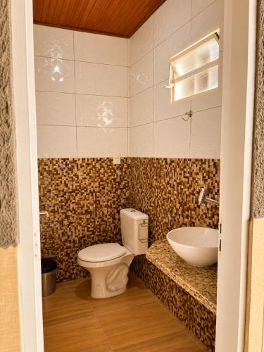 a bathroom with a toilet and a sink at Casa Chapadeira in Colinas Do Sul