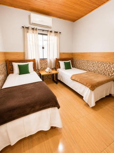 a bedroom with two beds and a window at Casa Chapadeira in Colinas Do Sul