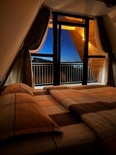 a bed in a room with a large window at Cabana Icas in Dej
