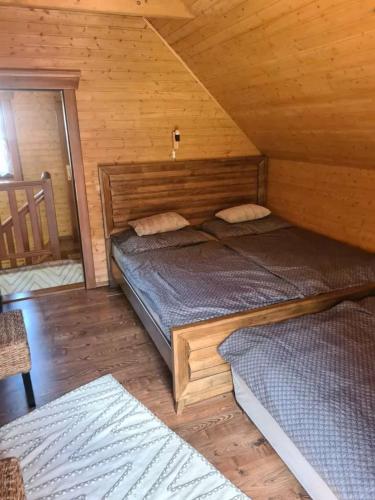 a bedroom with two beds in a wooden cabin at Zruby Liptovský Ján in Liptovský Ján