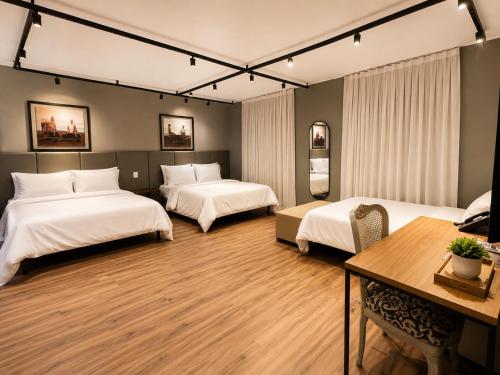a hotel room with two beds and a table at ibis Catanduva in Catanduva