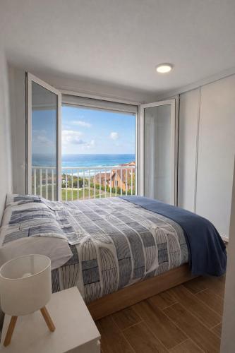 a bedroom with a bed and a large window at AuraGalega Vionta in Ribeira