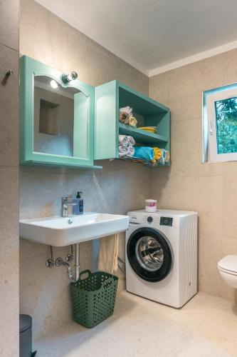 a bathroom with a washing machine and a sink at Apartmaji Skalabon - Milena in Kanal