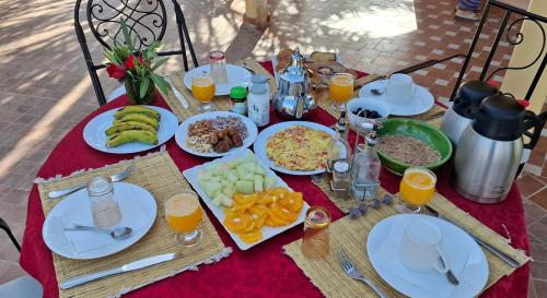 a table with plates of food and fruit on it at Oasis Tilogui-Luxury Hotel Restaurant and Desert Excursions In Zagora in Zagora