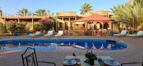a resort with a swimming pool in front of a house at Oasis Tilogui-Luxury Hotel Restaurant and Desert Excursions In Zagora in Zagora