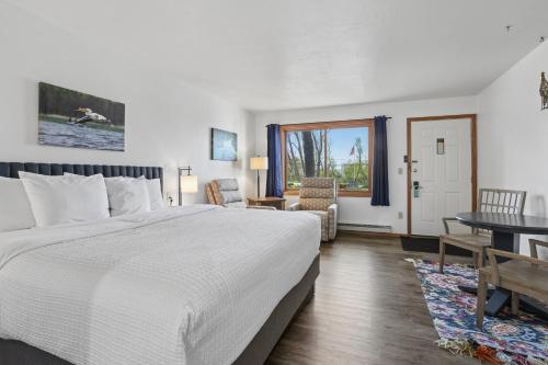 a bedroom with a bed and a table and chairs at Parkside Inn in Ellison Bay