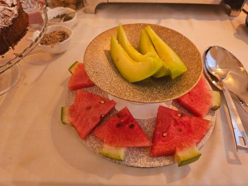 a plate of watermelon and other fruits on a table at Villa Olympia in Durrës
