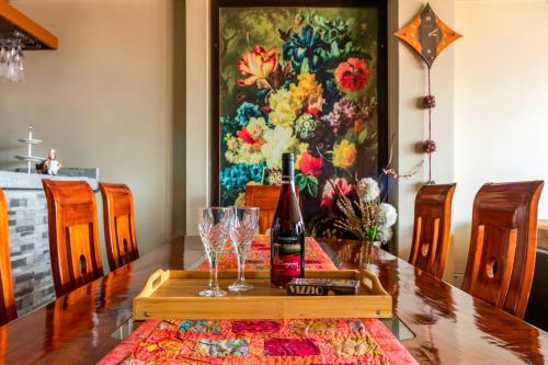 a table with a bottle of wine and glasses on it at El Balcón del Sol - Dpto Céntrico con Vistas Perfectas in Cusco