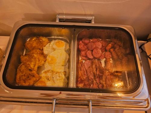 a tray of food with meat and eggs in an oven at Villa Olympia in Durrës