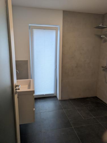 a bathroom with a sink and a door with a window at Komfortables 2-Zimmer Apartment in Rinteln in Rinteln