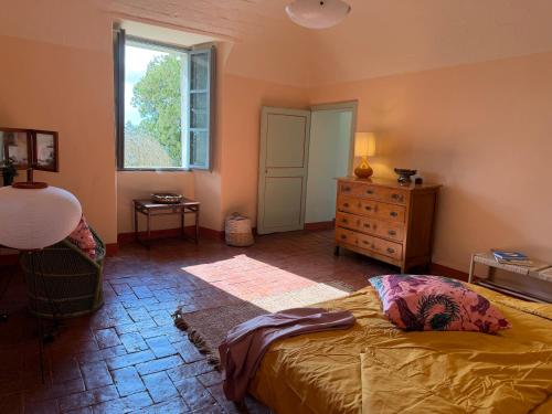 a bedroom with a bed and a window and a dresser at Le Guadalupe by Luigi in Volterra