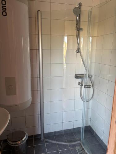 a shower with a glass door in a bathroom at Smedjan Bed and Breakfast in Varberg