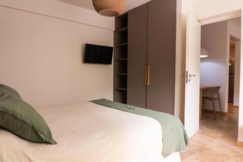 a bedroom with a white bed and a closet at DEPARTAMENTO en MENDOZA centro, moderno y cálido, Parking - Lavandería in Mendoza