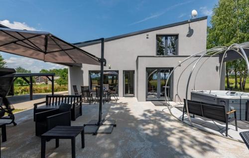 a patio with benches and tables and a building at Country house Greenfields in Gospić