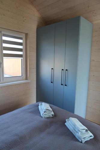 a bedroom with a bed and a cabinet and a window at Domki Paradise Charzykowy in Charzykowy