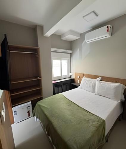 a bedroom with a bed and a window at Pousada Beach in Capão da Canoa