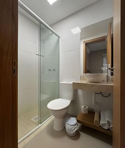 a bathroom with a shower and a toilet and a sink at Pousada Beach in Capão da Canoa