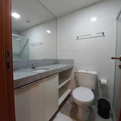 a white bathroom with a toilet and a sink at Freitas Residence - Quinta Manuel Rodrigues in Recife