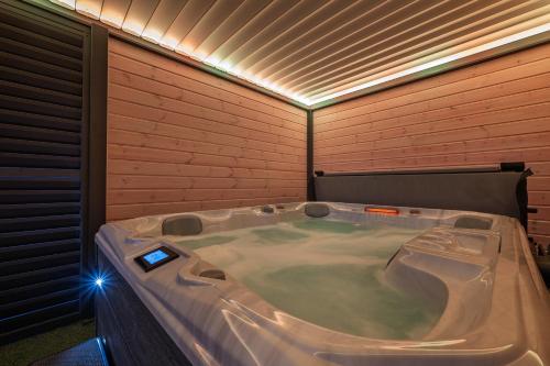 a jacuzzi tub in a room with a brick wall at Domki SUNSET Bałtycka in Dąbki