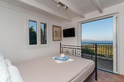 a bedroom with a bed and a view of the ocean at Skatza Ocean Crest in Kamária