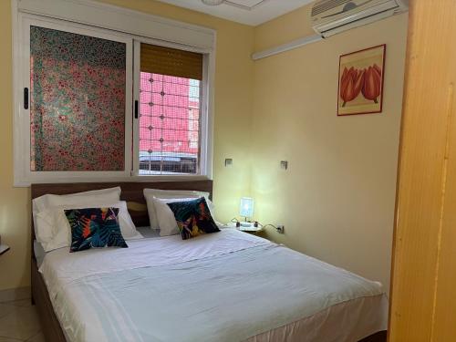 a bedroom with a white bed with a window at saidia 700 m de la plage in Saïdia