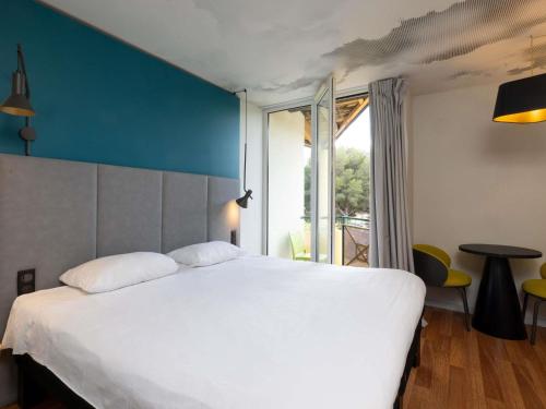 a bedroom with a large white bed and a window at ibis Sète Balaruc les Bains Bien-être et Spa in Balaruc-les-Bains
