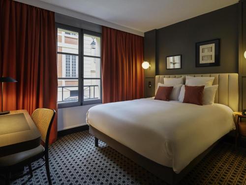a hotel room with a large bed and a window at Mercure Versailles Chateau in Versailles