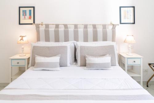 a white bedroom with a large white bed with white pillows at Queen Suite - Luxury Rooms in Forio d'Ischia