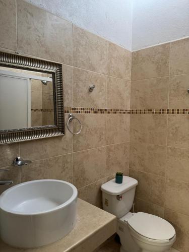 a bathroom with a tub and a toilet and a sink at Casa Flamingo in Bucerías