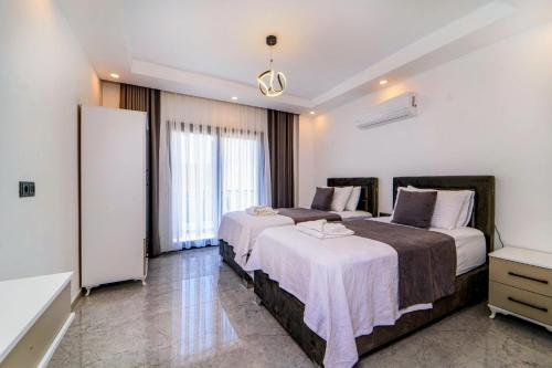 a hotel room with two beds and a refrigerator at Olive villas in Fethiye