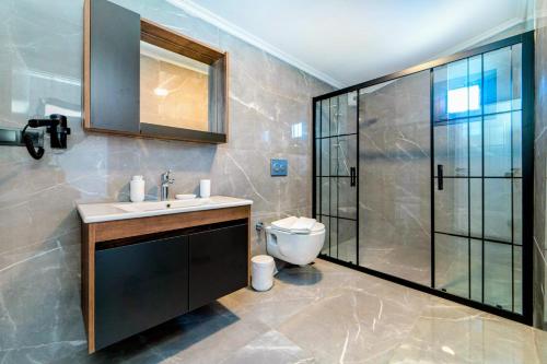 a bathroom with a toilet and a sink and a shower at Olive villas in Fethiye