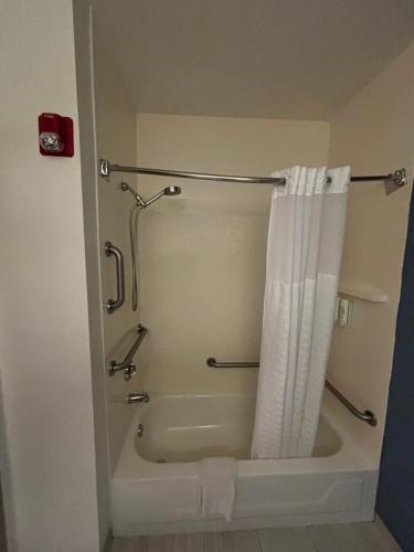 a bathroom with a bath tub with a shower curtain at Sleep Inn & Suites Pensacola - University Area in Pensacola